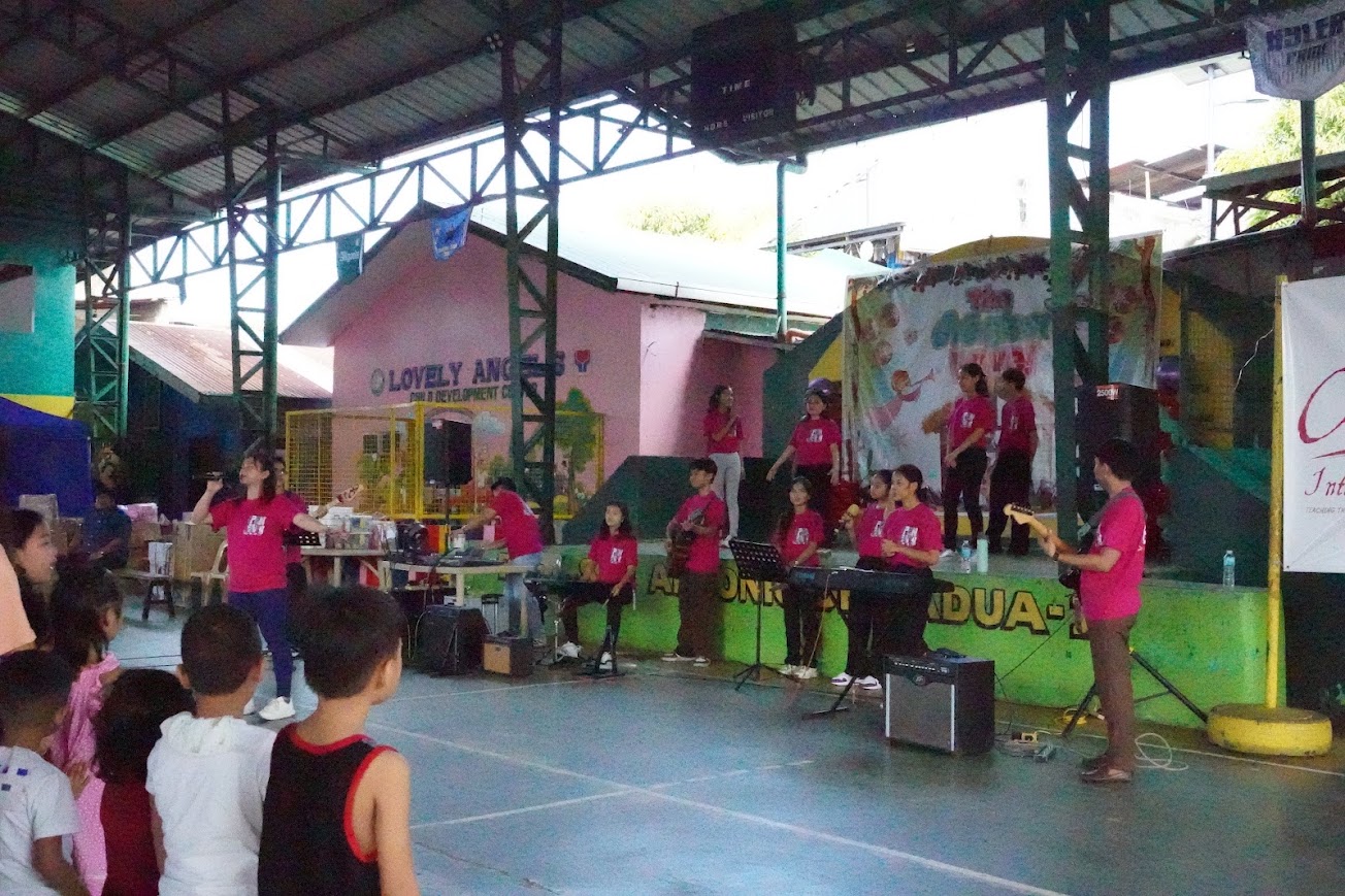 Children standing at their chairs, the whole court filling in.