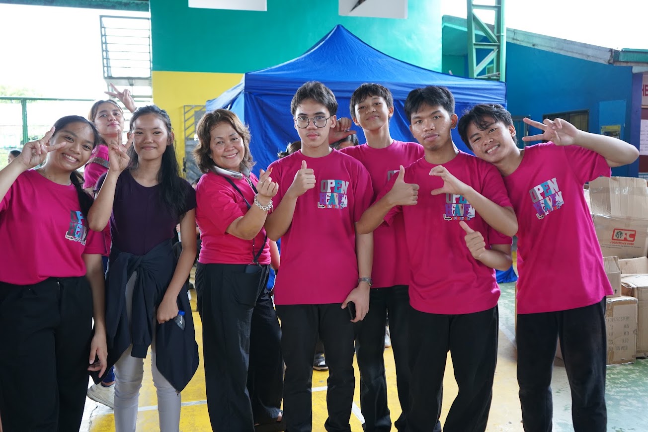 Youth volunteers with a team leader, thumbs up between sessions.