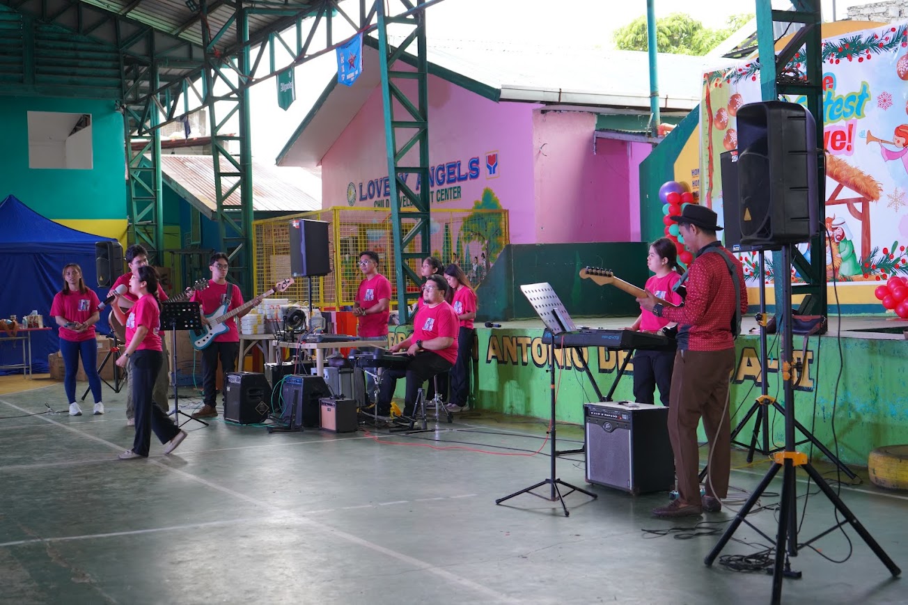 The worship band on the court — vocalist, guitars, keys, the sound rig behind.