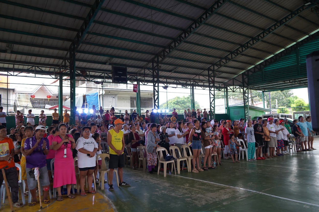 Community members applaud along the front row.