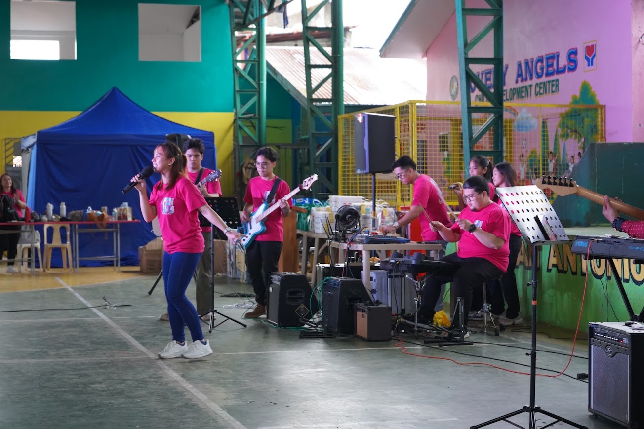 The band and singers perform in front of the stage.