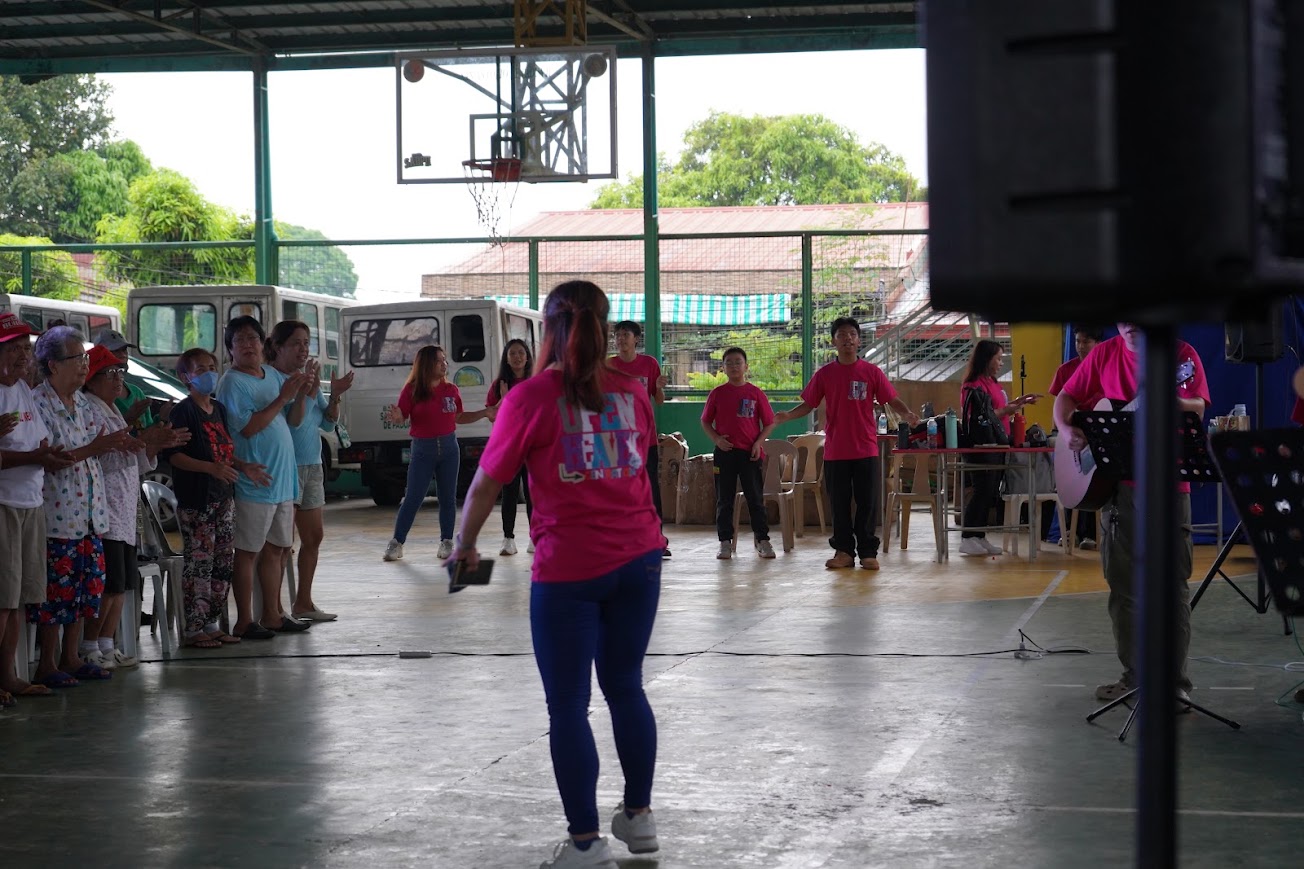 The team leads the crowd in worship from the center of the court.