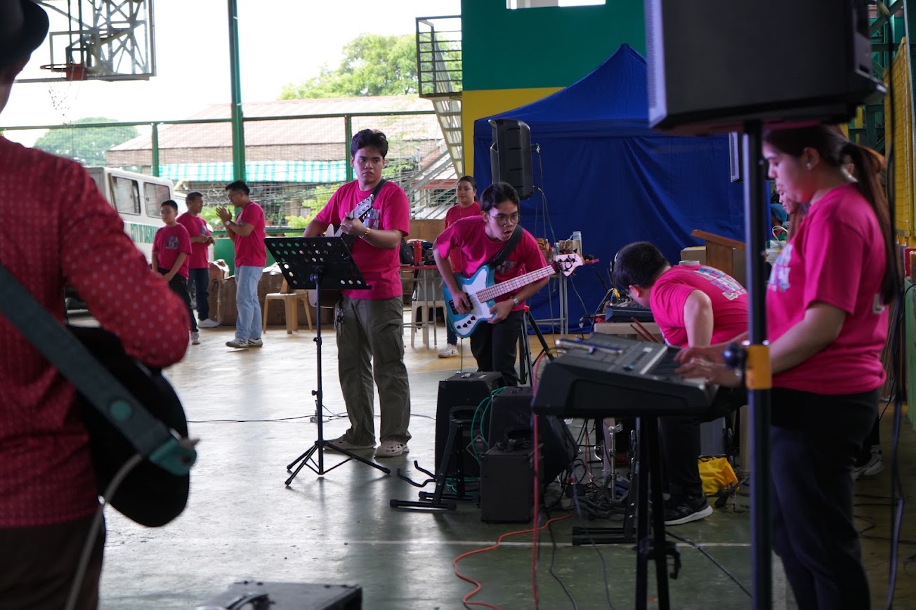 The band mid-song, the team gathered at the far end.