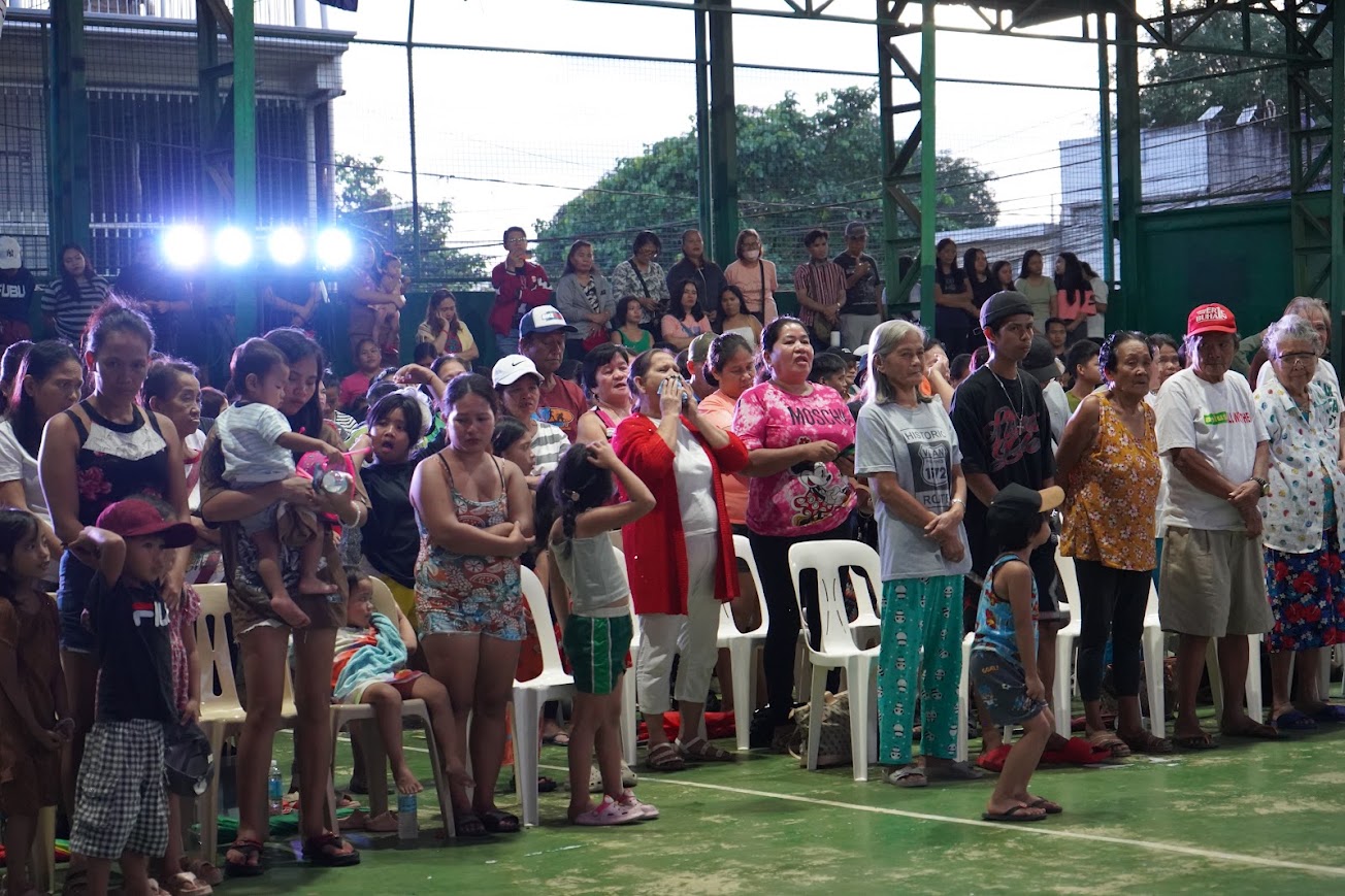 Families standing at their seats as the afternoon program opens.