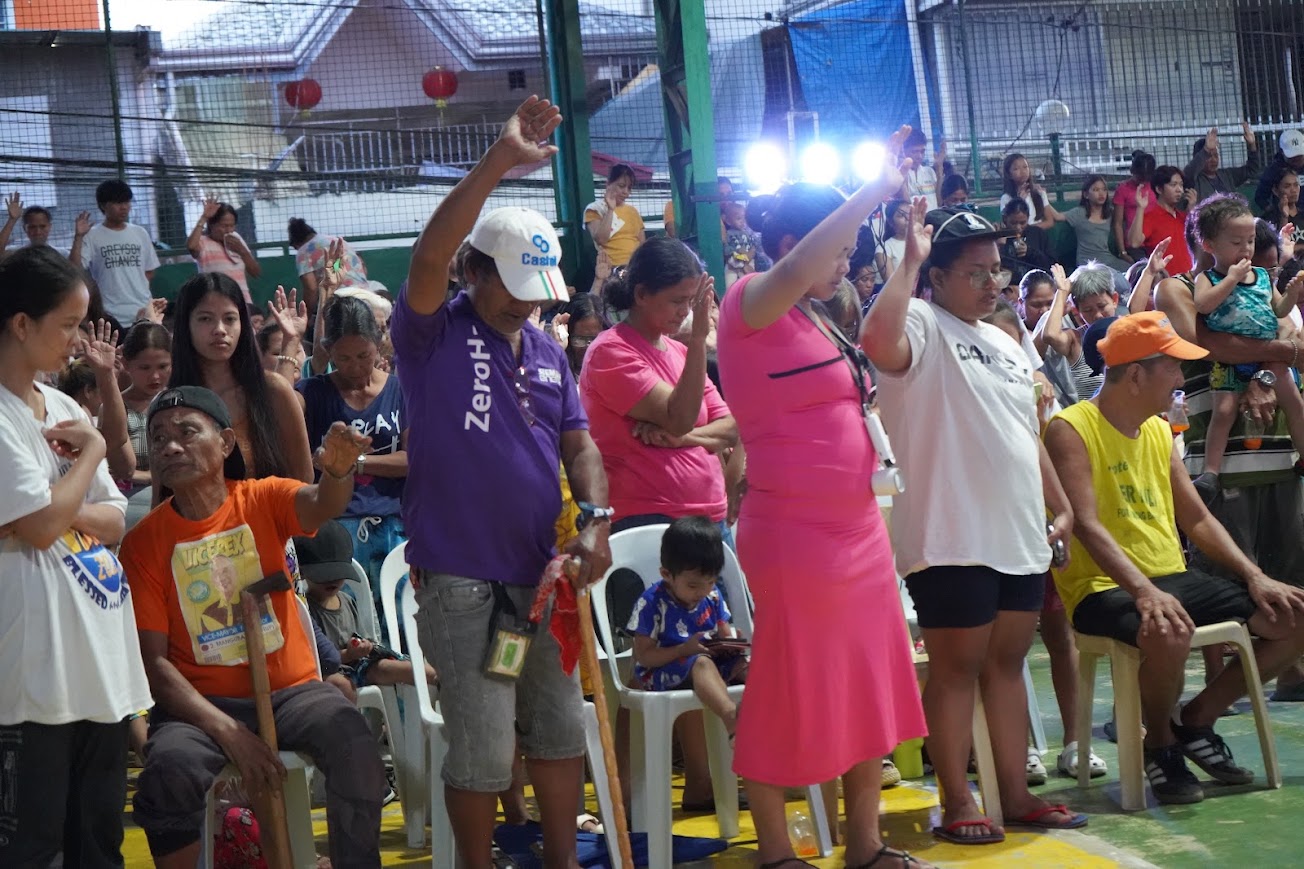 The whole court standing, hands raised in the afternoon light.
