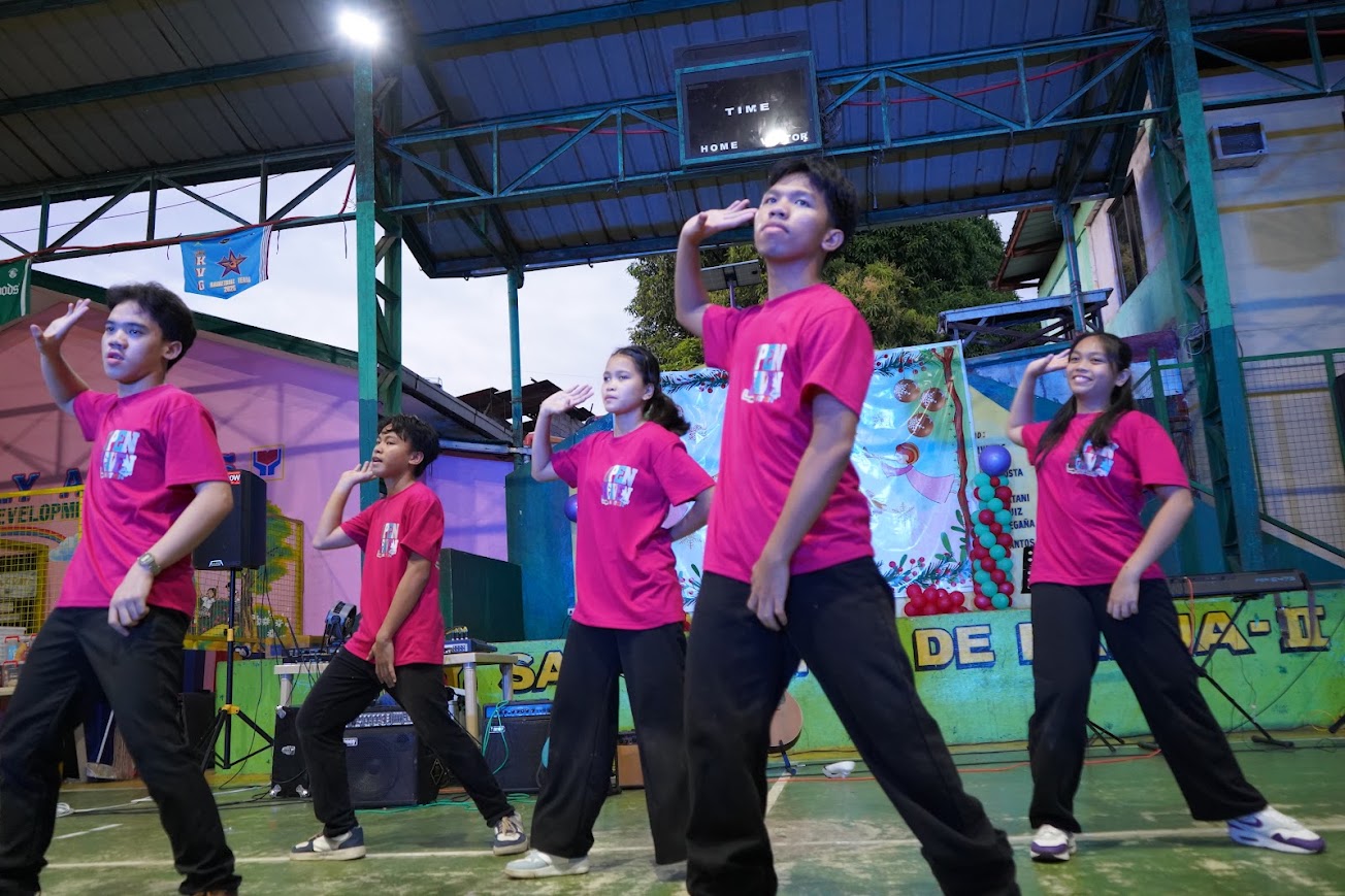 Five youth dancers mid-routine on the court.