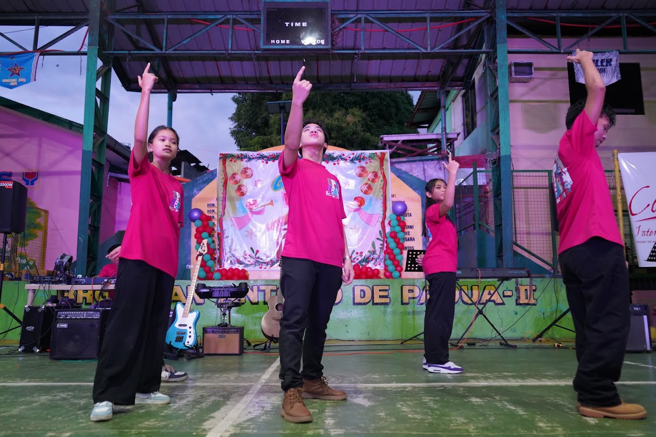 The dance team, arms raised, the Covenant banner at right.
