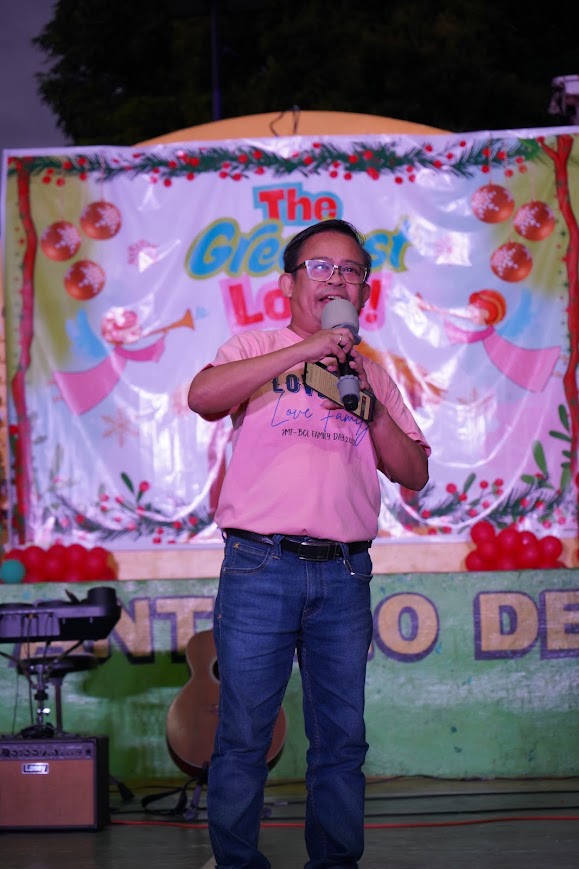A speaker at the mic in front of the nativity backdrop.
