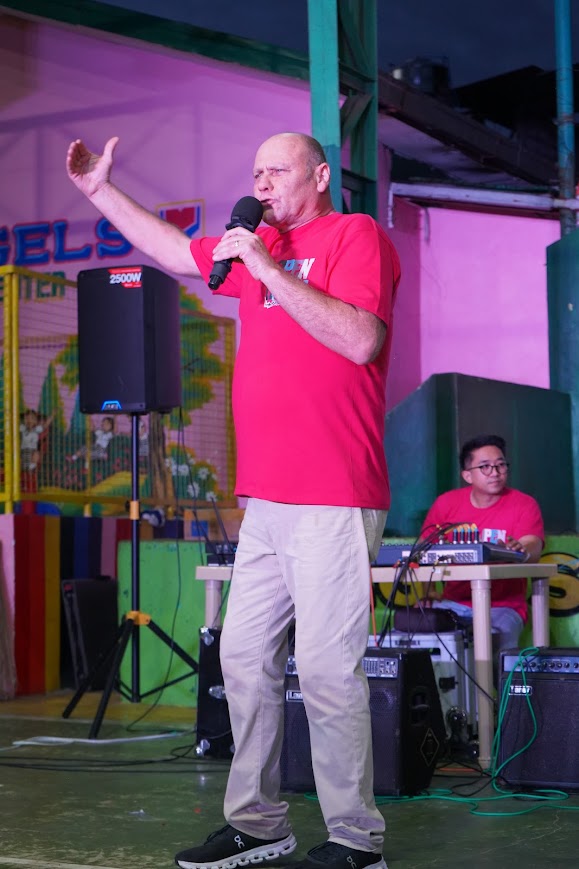 A team member addresses the crowd from the front of the stage.