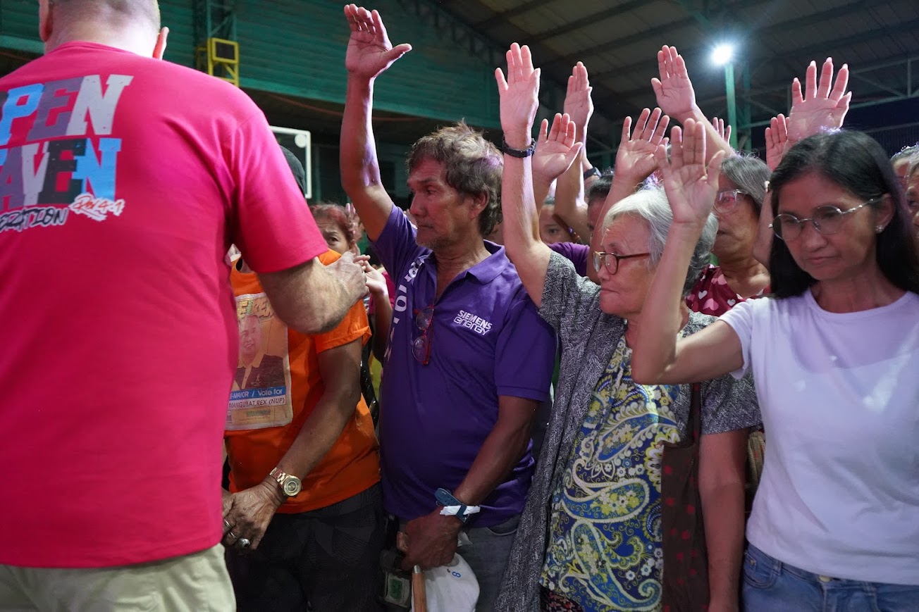 Hands raised across the crowd as a team member walks through.