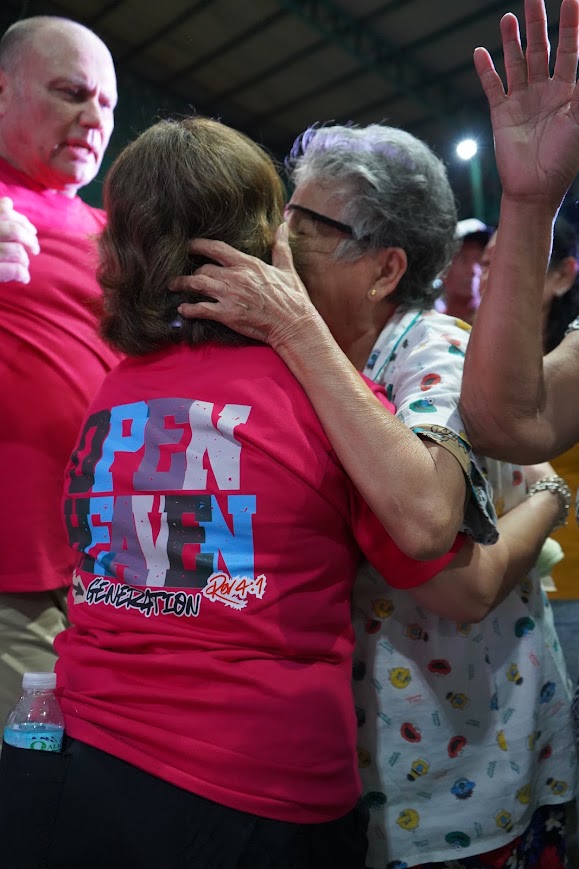 A team member embraces an elder in prayer.