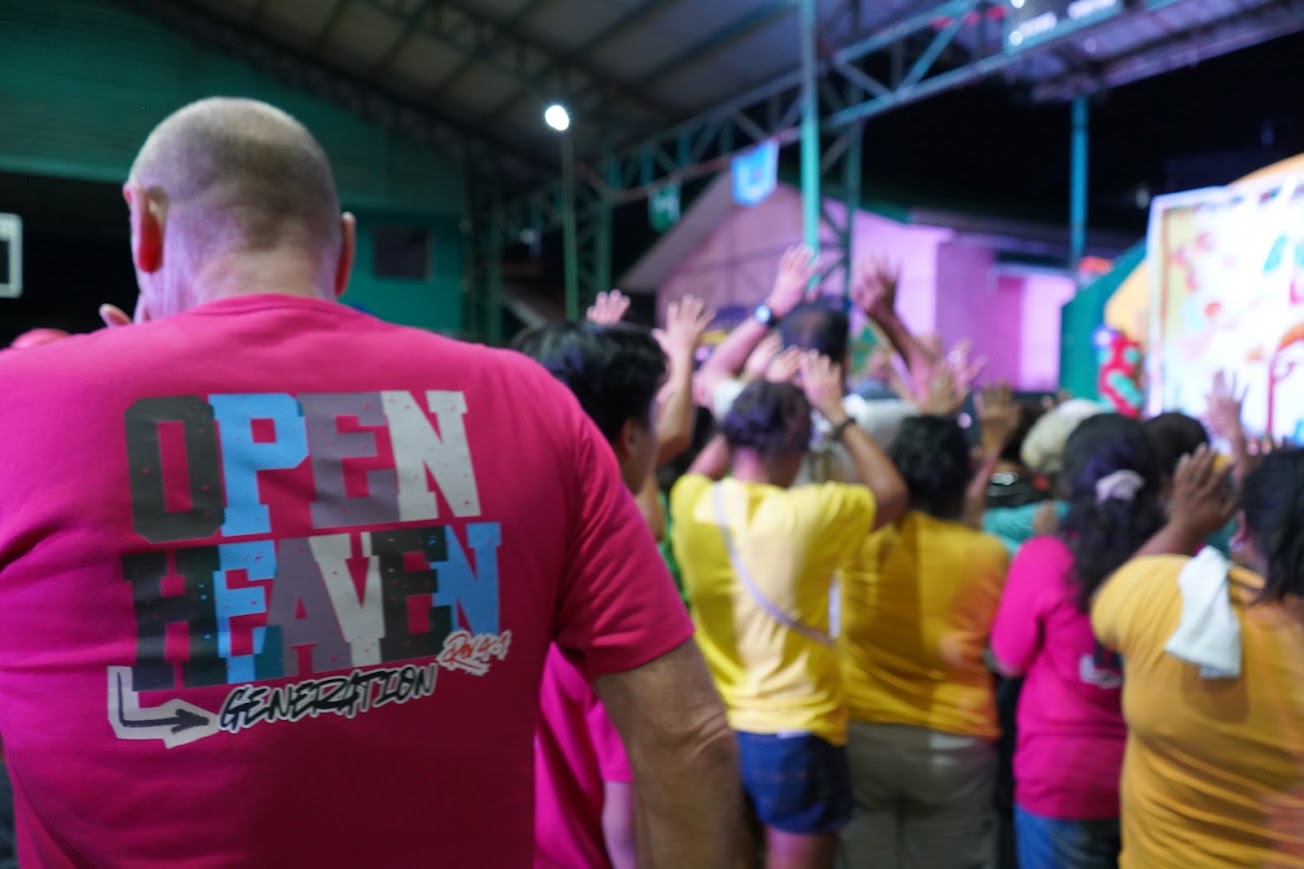 From behind the team — hands lifted toward the stage.