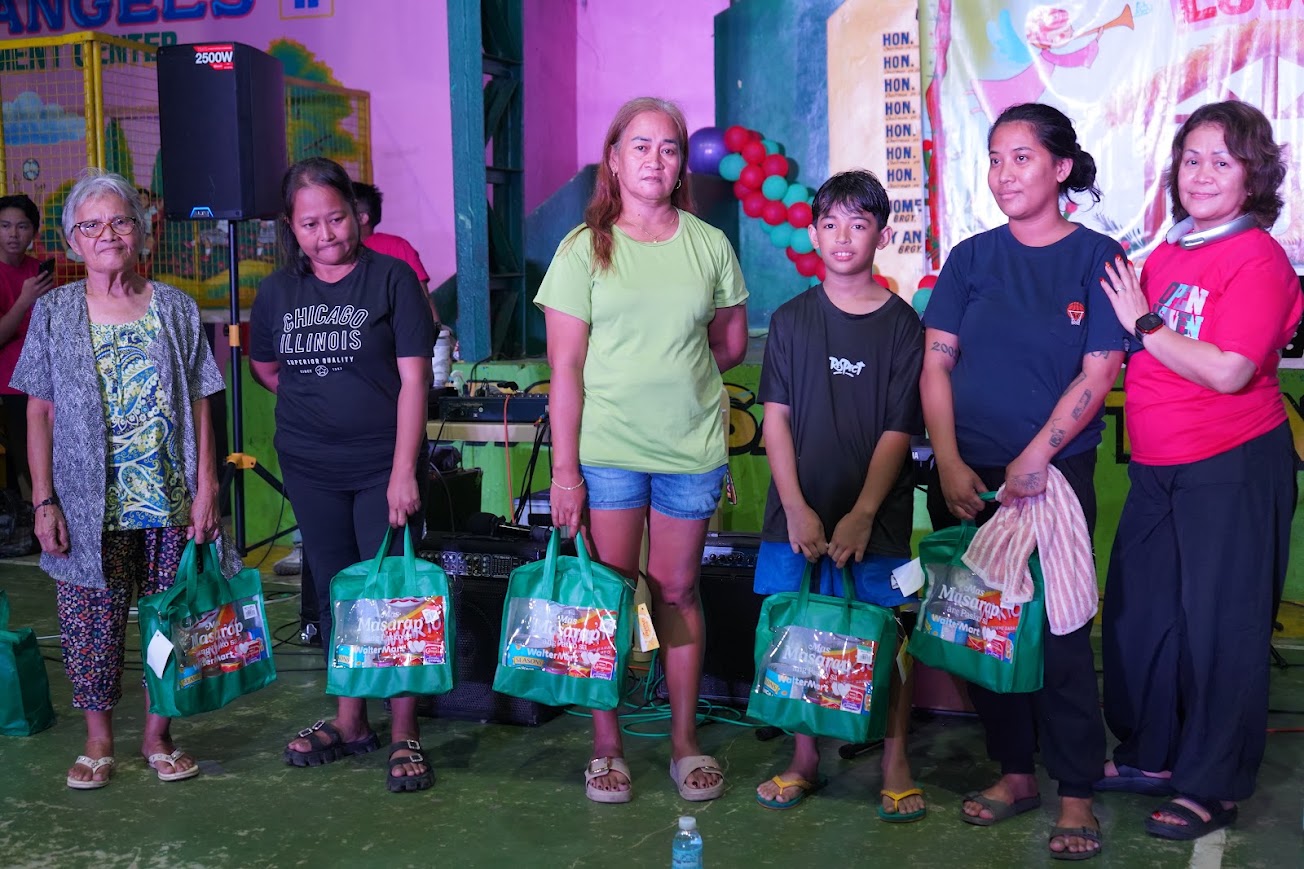 The team on stage under "The Greatest Love!" for the raffle draw.