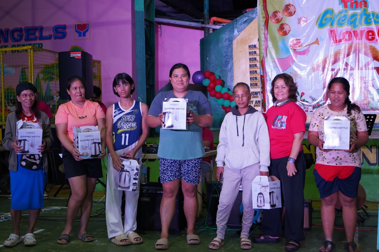 A washing machine presented to a community member on stage.