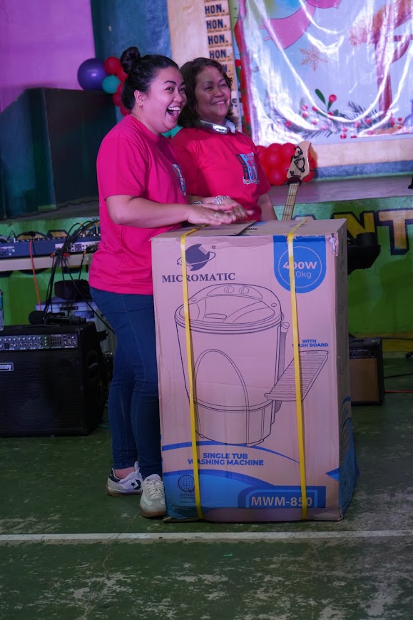 Team members with a washing machine — a moment of celebration.