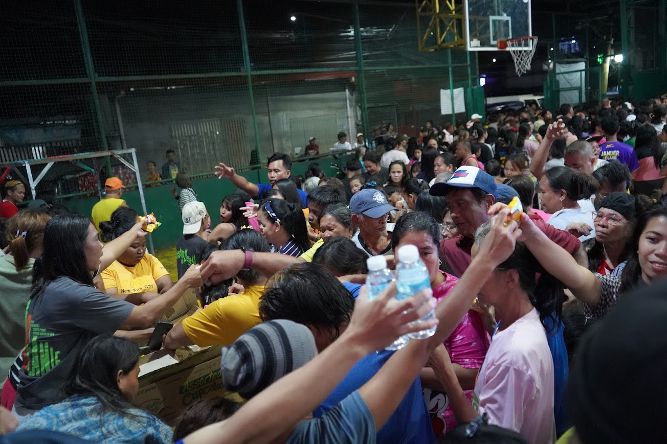 Snacks and water handed out from the boxes, hands reaching in.