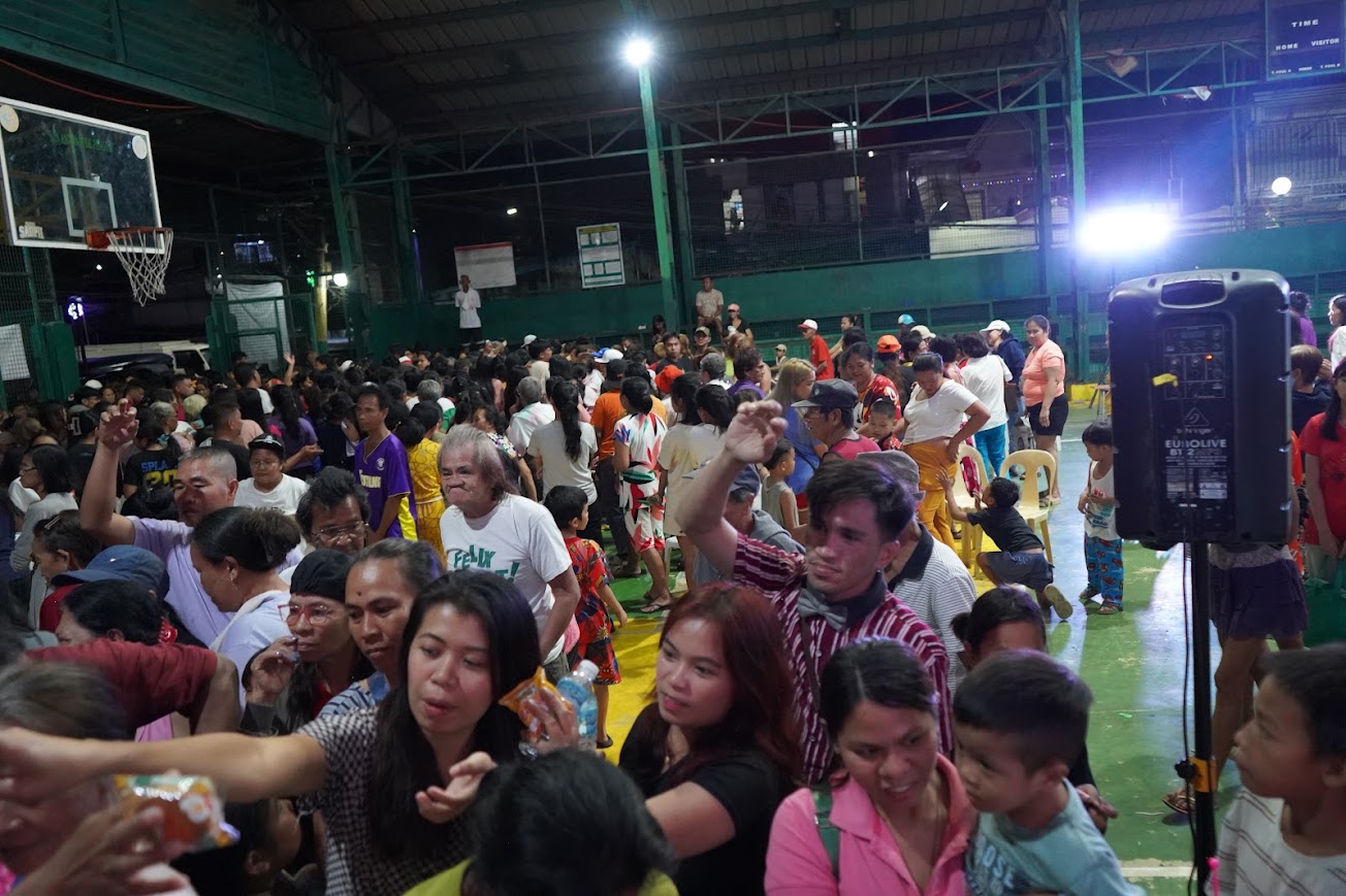 A team member hands packs across the crowd.