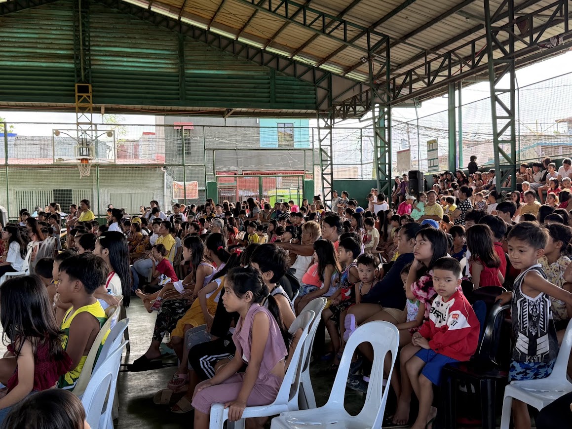 From the side — children in the front rows, the rest of the court behind.