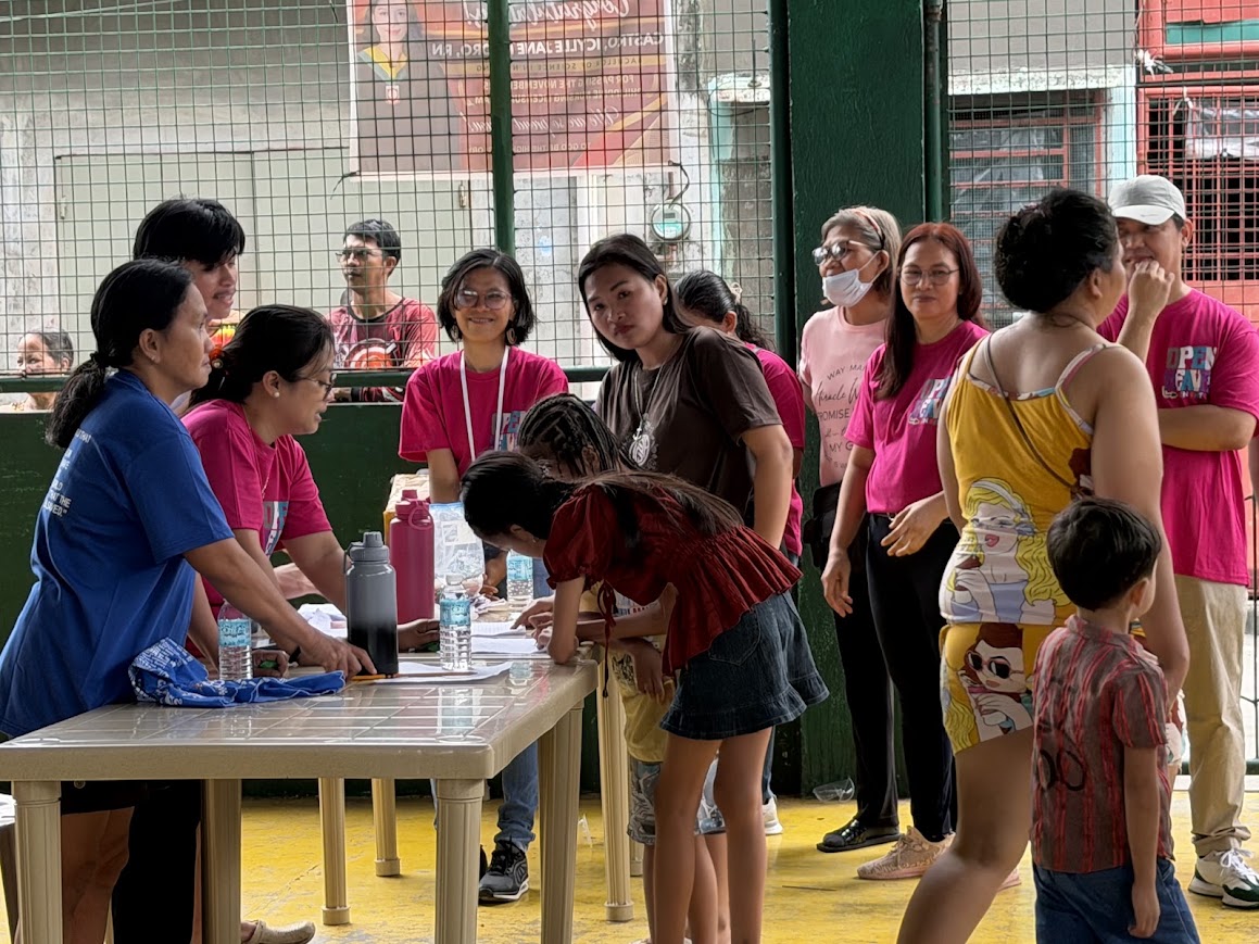 Registration — a child signs in as the team looks on.
