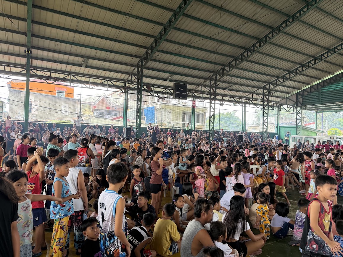 Standing room only — children and families to the far wall.