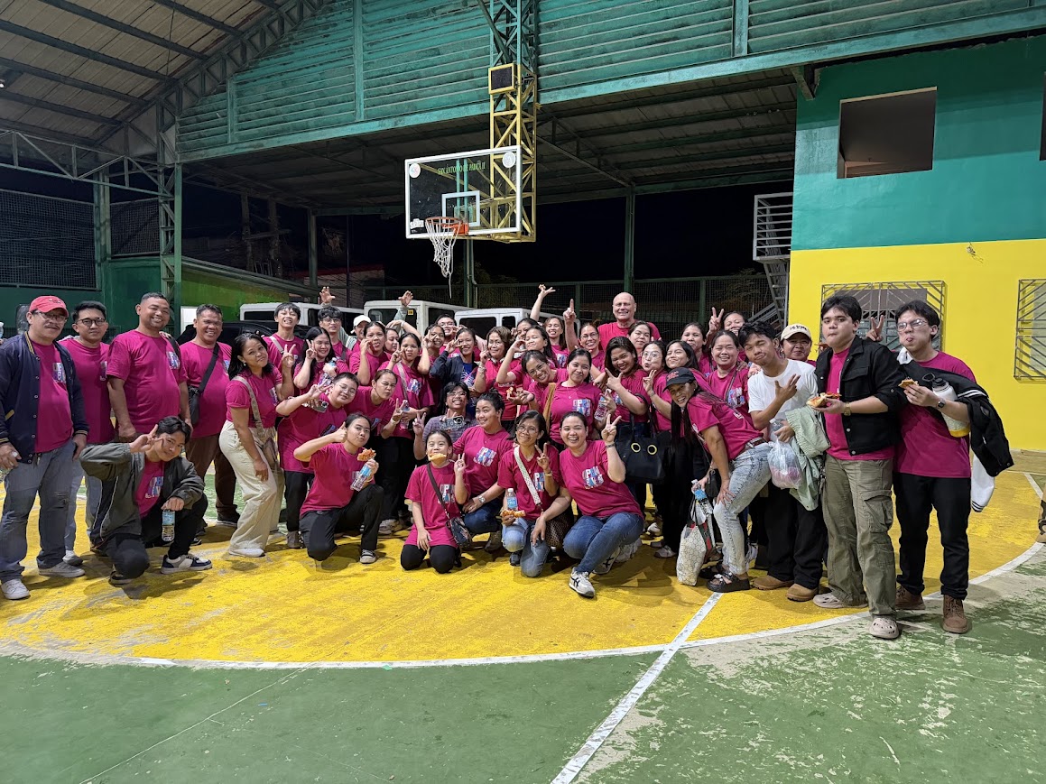 The full volunteer team gathers on the court at the end of the night.