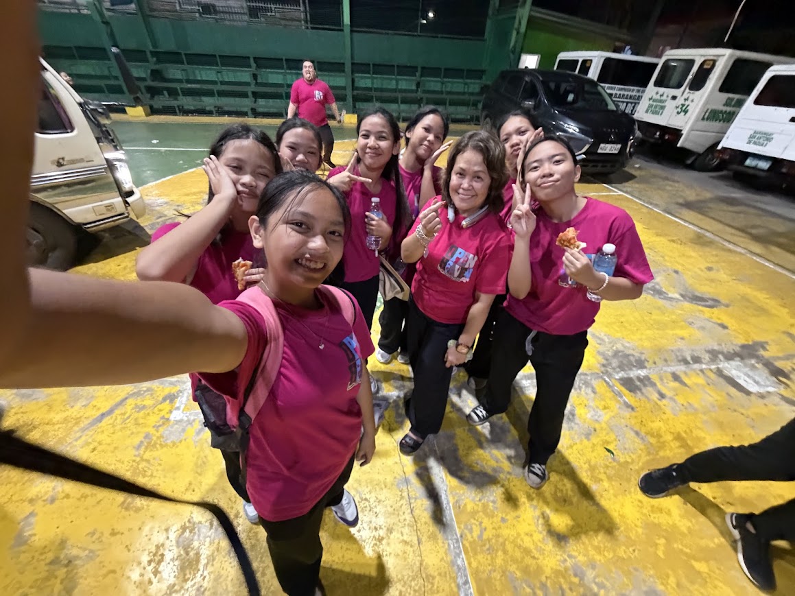 Youth volunteers take a selfie on the court after the event.