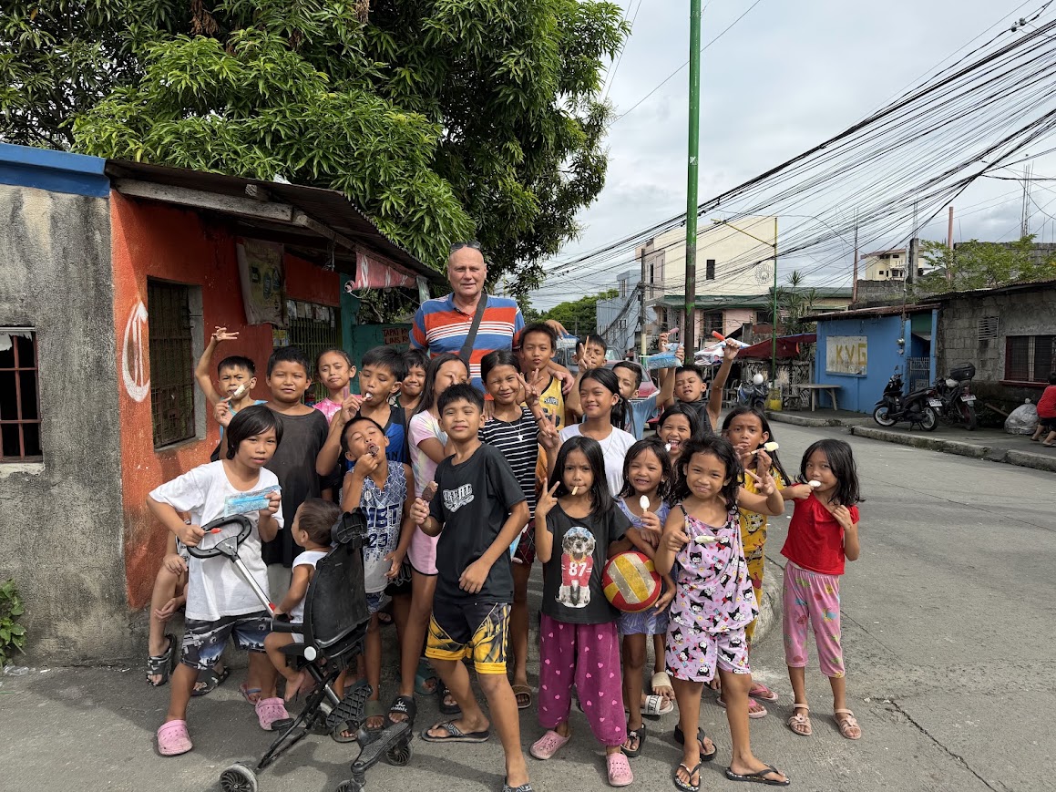 A street visit two days later — a team member with a crowd of neighborhood kids, ice cream in hand.