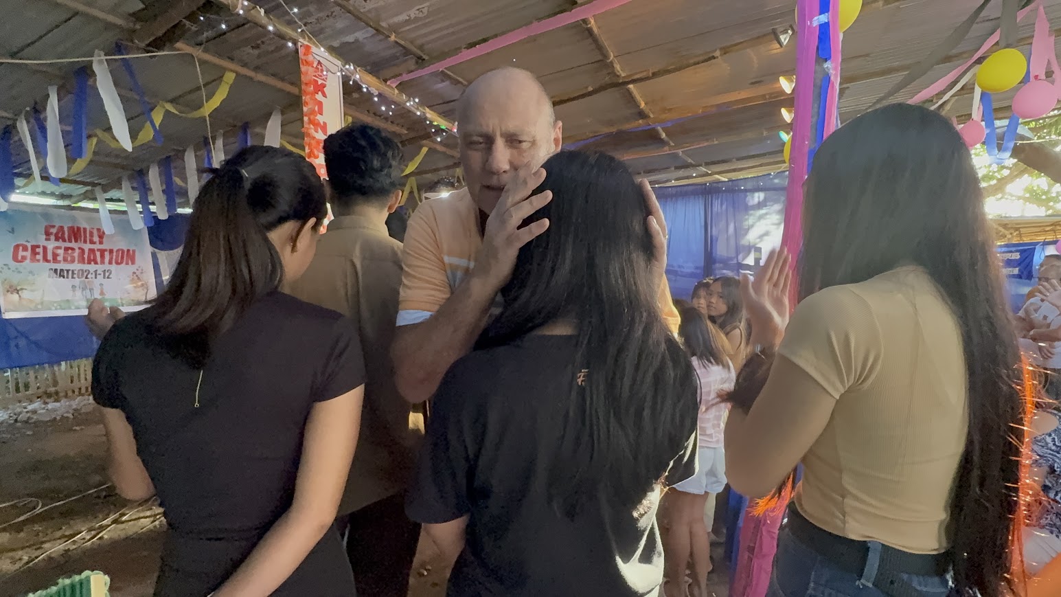 Prayer shared with a young woman, surrounded by community support.