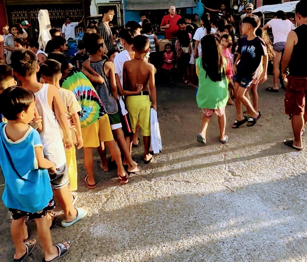 The line stretches past the shophouses in the late afternoon light.