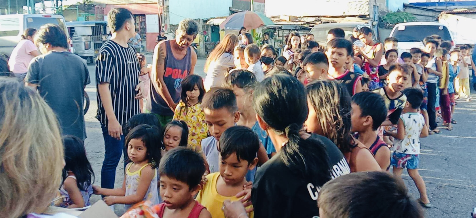 The head of the line, a woman in black keeping the children in order.