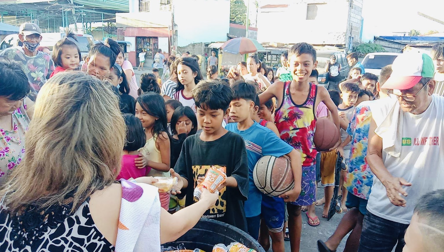 Bread for a boy in a tie-dye shirt, another basketball behind him.