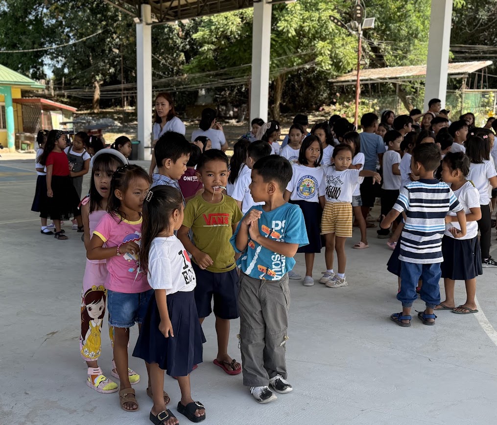 Students gathering under the covered court to welcome the team.