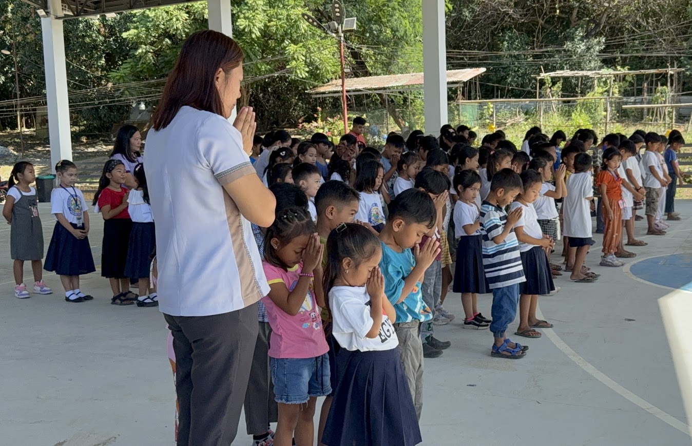 A teacher leads the students in prayer.