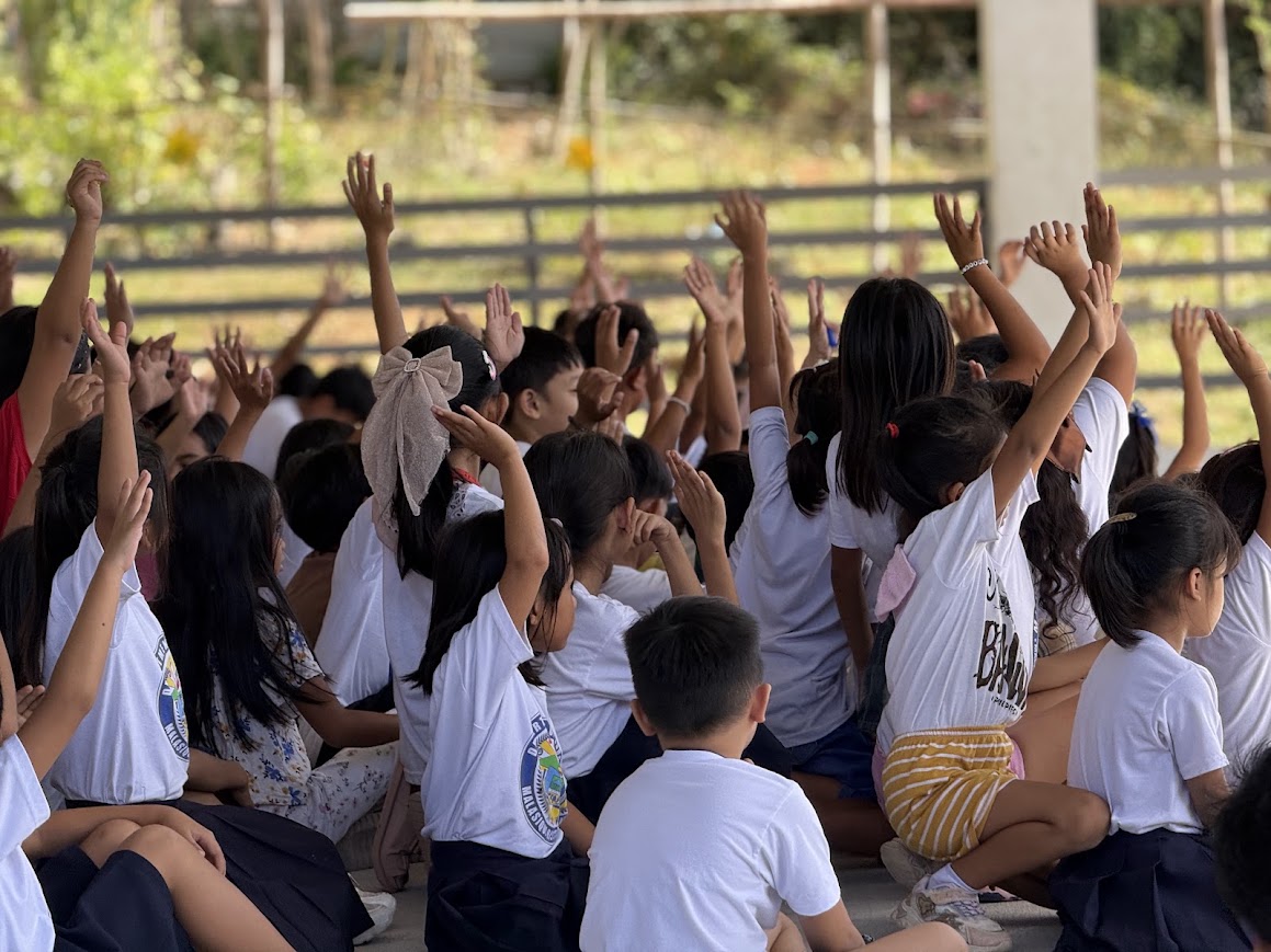 Students bow their heads together.