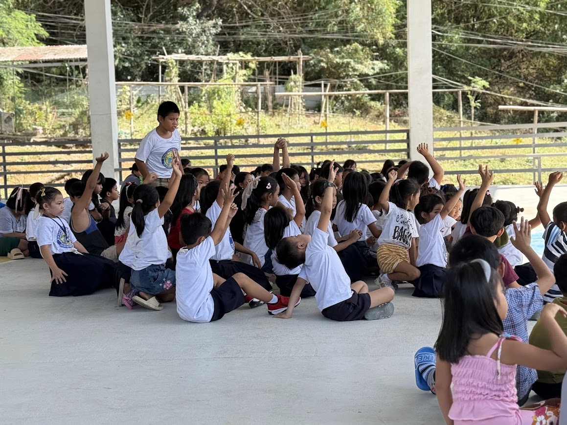 Students raise their hands in worship.