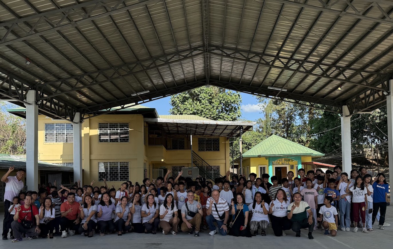 A group photo with students and teachers back at the school.