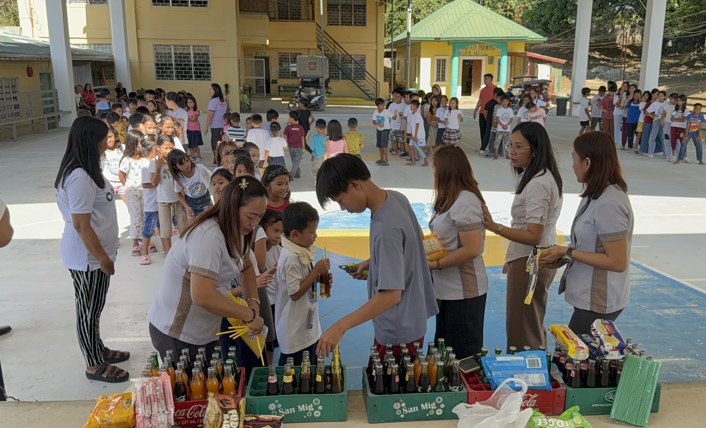 Children lining up for drinks and snacks.