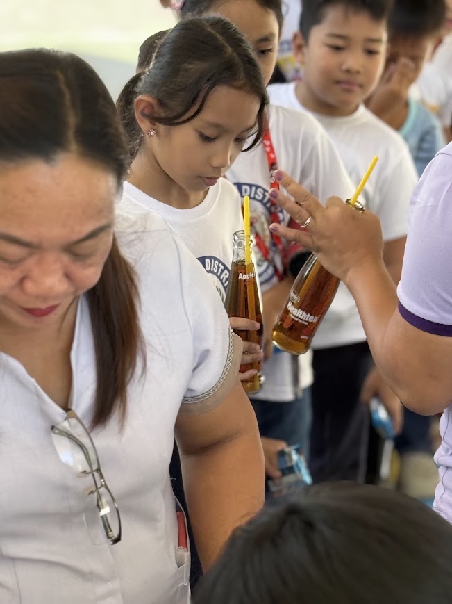 Handing out bottled drinks to the children.