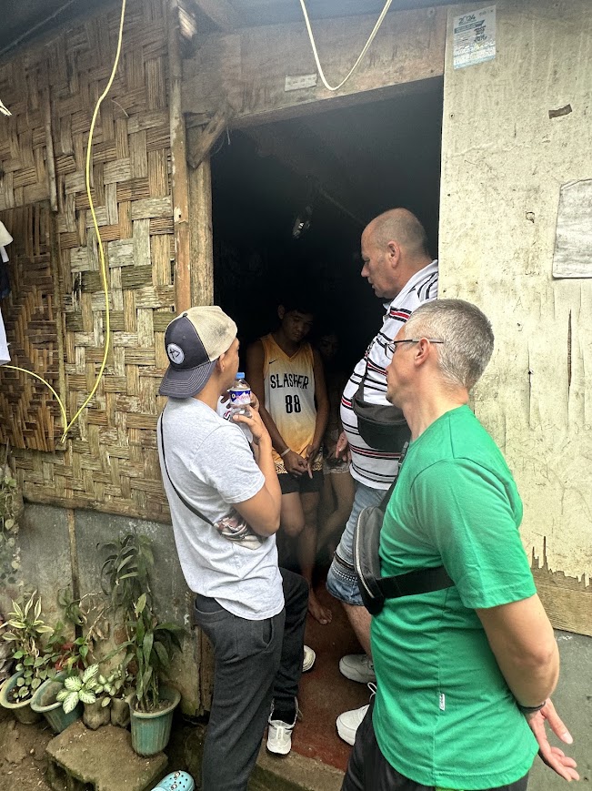 A team member greets a family at their door in the barangay.