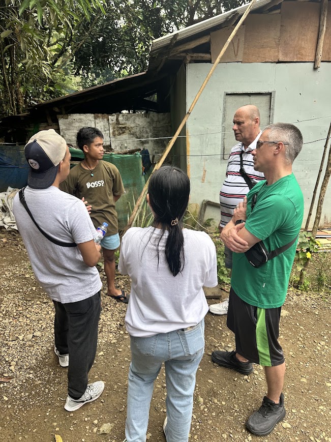 The team speaks with a young man outside his home.