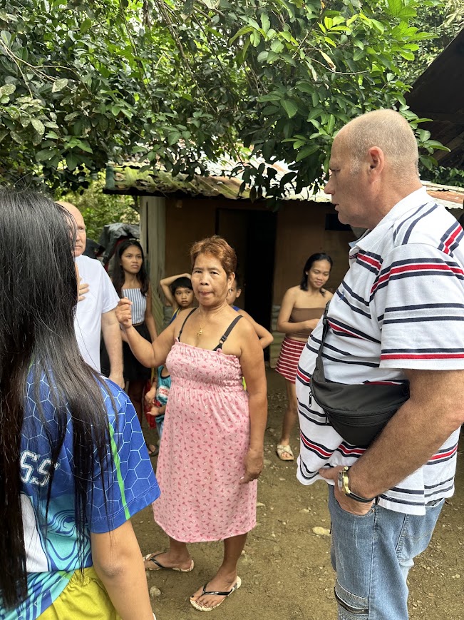 A visit at a doorway — the team speaks with a family from the step.