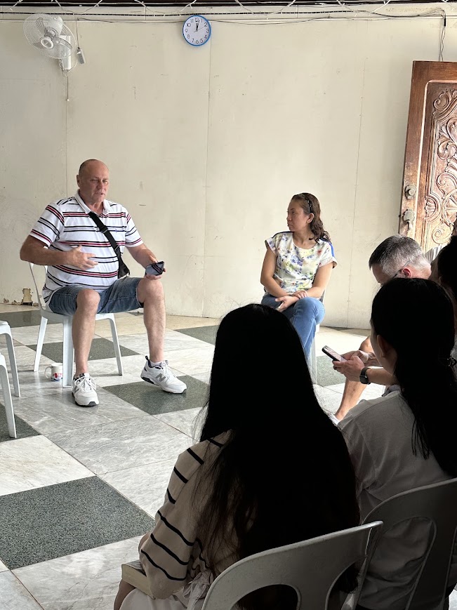 A team member shares with the group, seated in a circle.