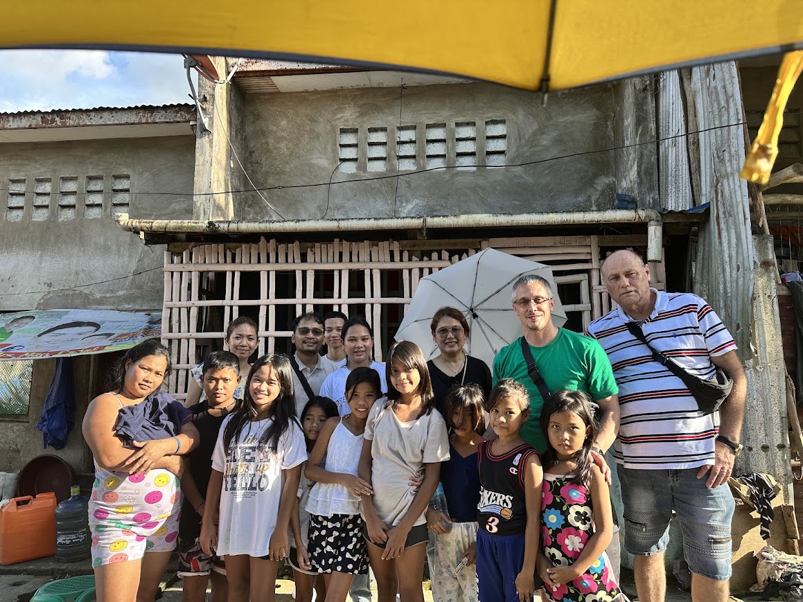 Thumbs up all round — the team and the family at their home.