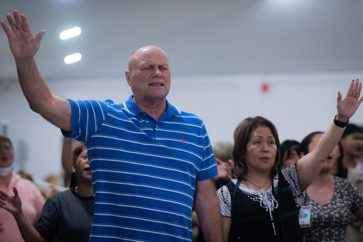 Worship — the congregation with hands raised.