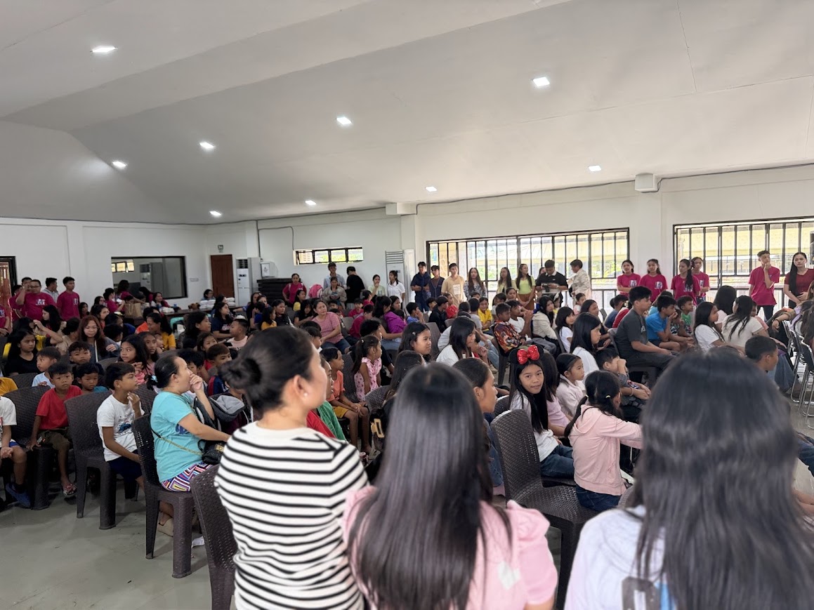 The crowd from the side, youth volunteers lining the far wall.