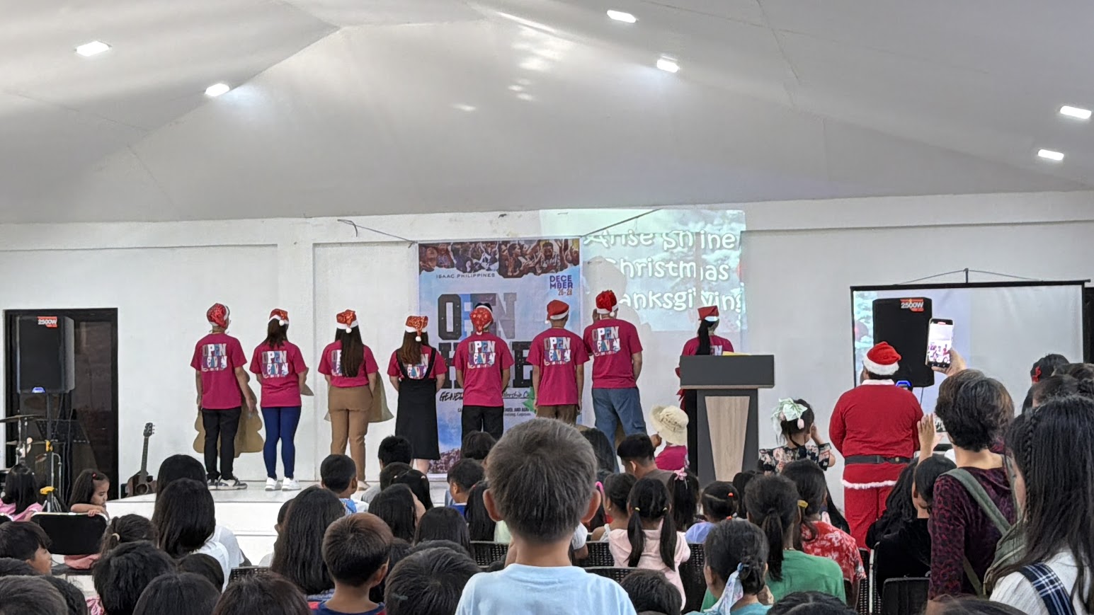The Christmas skit opens — the cast turned away, the screen reading "Arise Shine Christmas Thanksgiving".