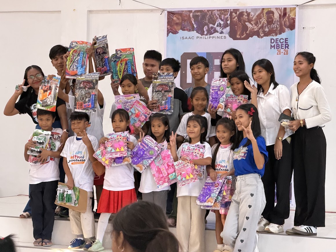 Children line the stage with their toys.