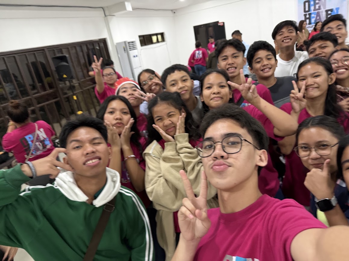 A wide selfie of the youth group, a Santa hat in the back row.