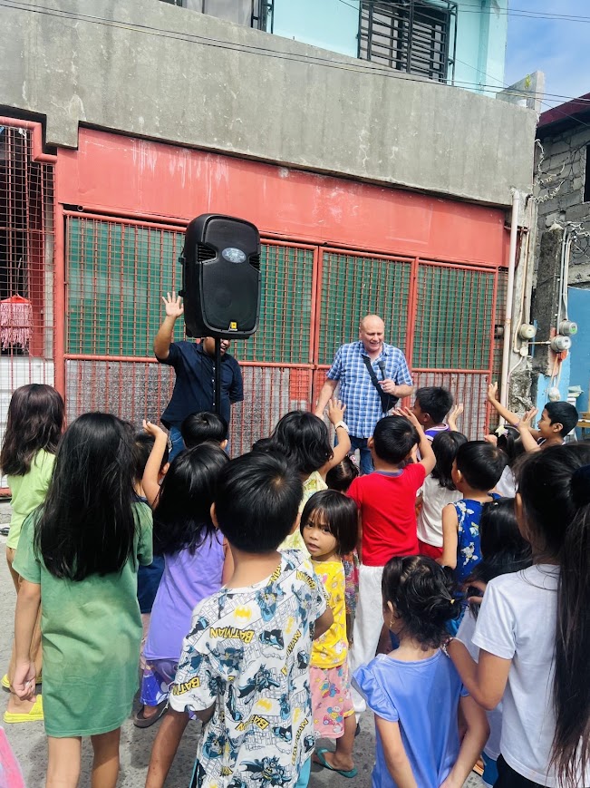 A quick stop outside a neighbor's gate, sharing a word with the children before heading to the court.