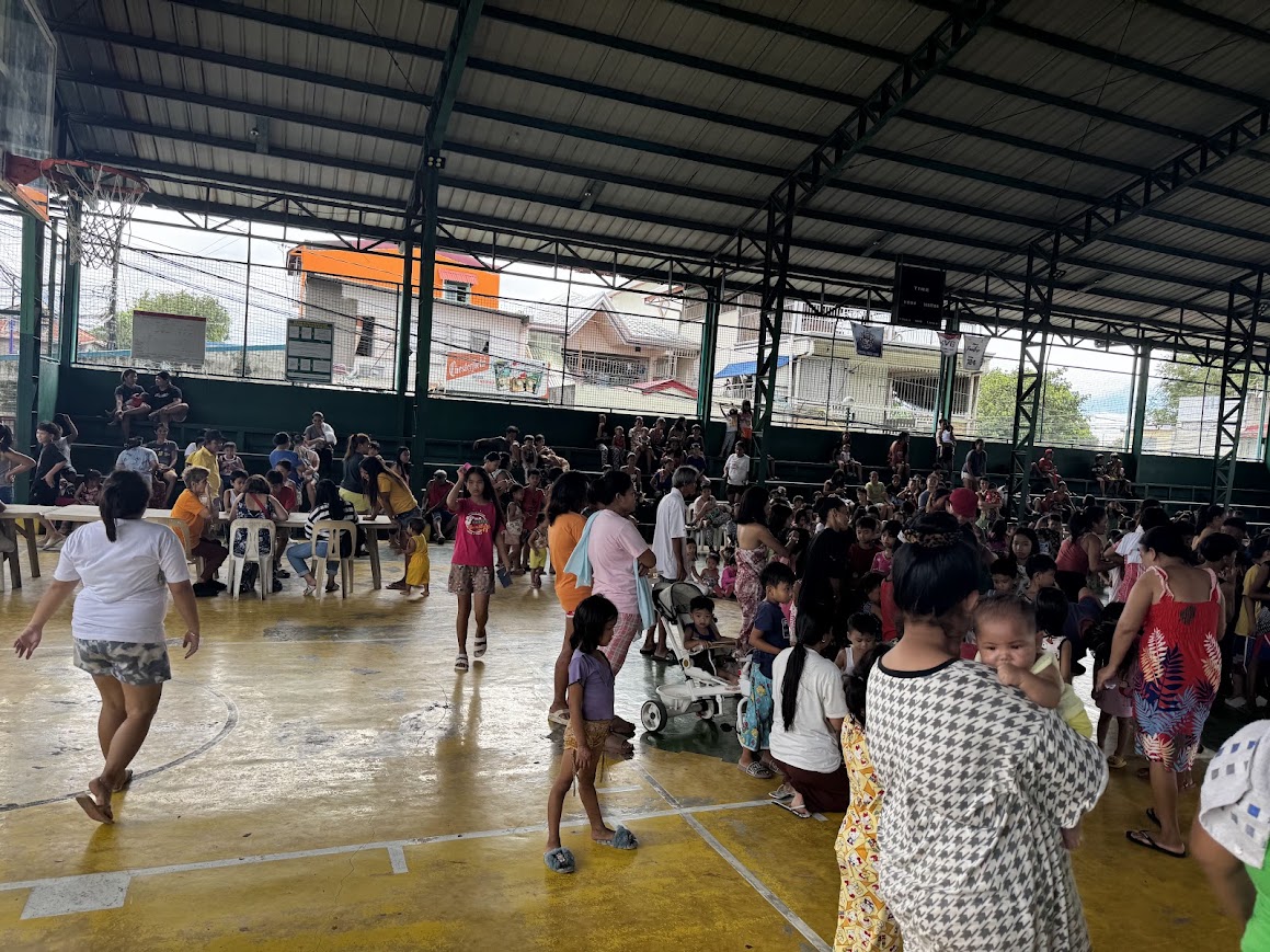 Families continue to arrive — strollers, infants, and grandparents settling in at the tables.